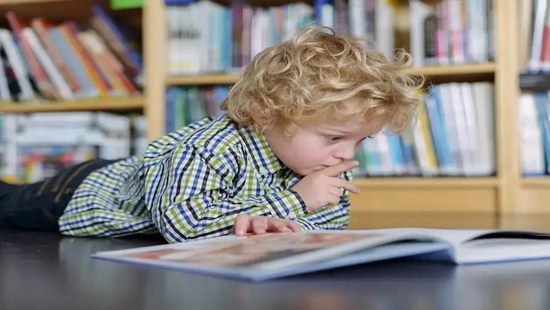 طفل يقرا في كتاب في مكتب