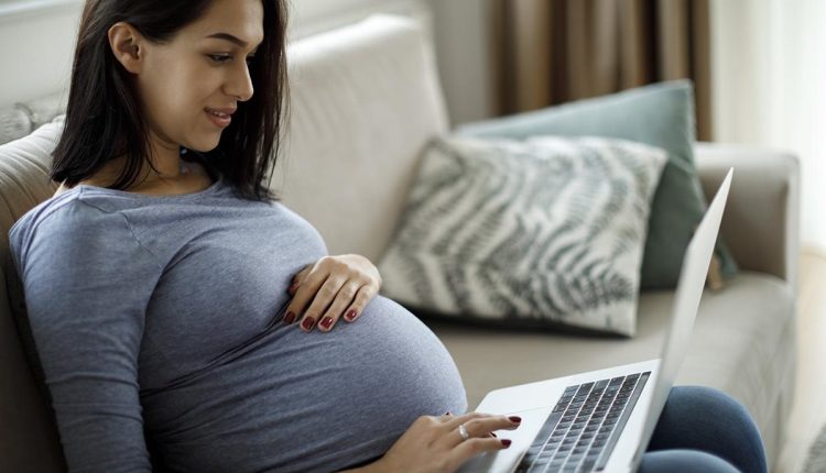 المرأة الحامل مع الكمبيوتر